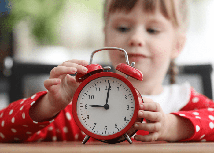 Child setting an alarm clock. 