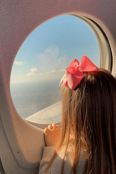 little girl looking out of airplane window