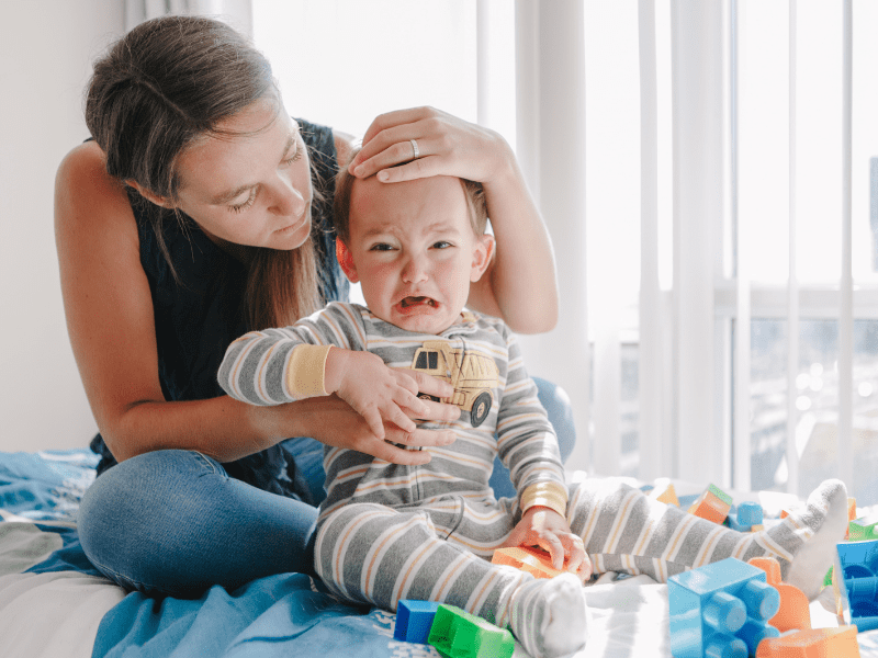 toddler upset, clinging to mom