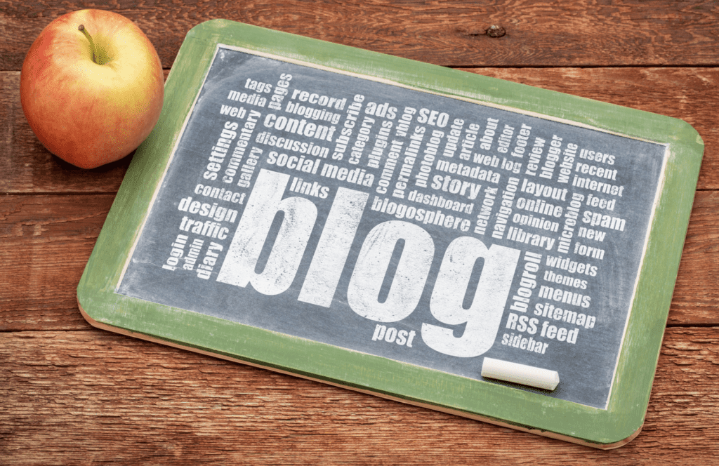 blogging terms on white chalkboard with apple